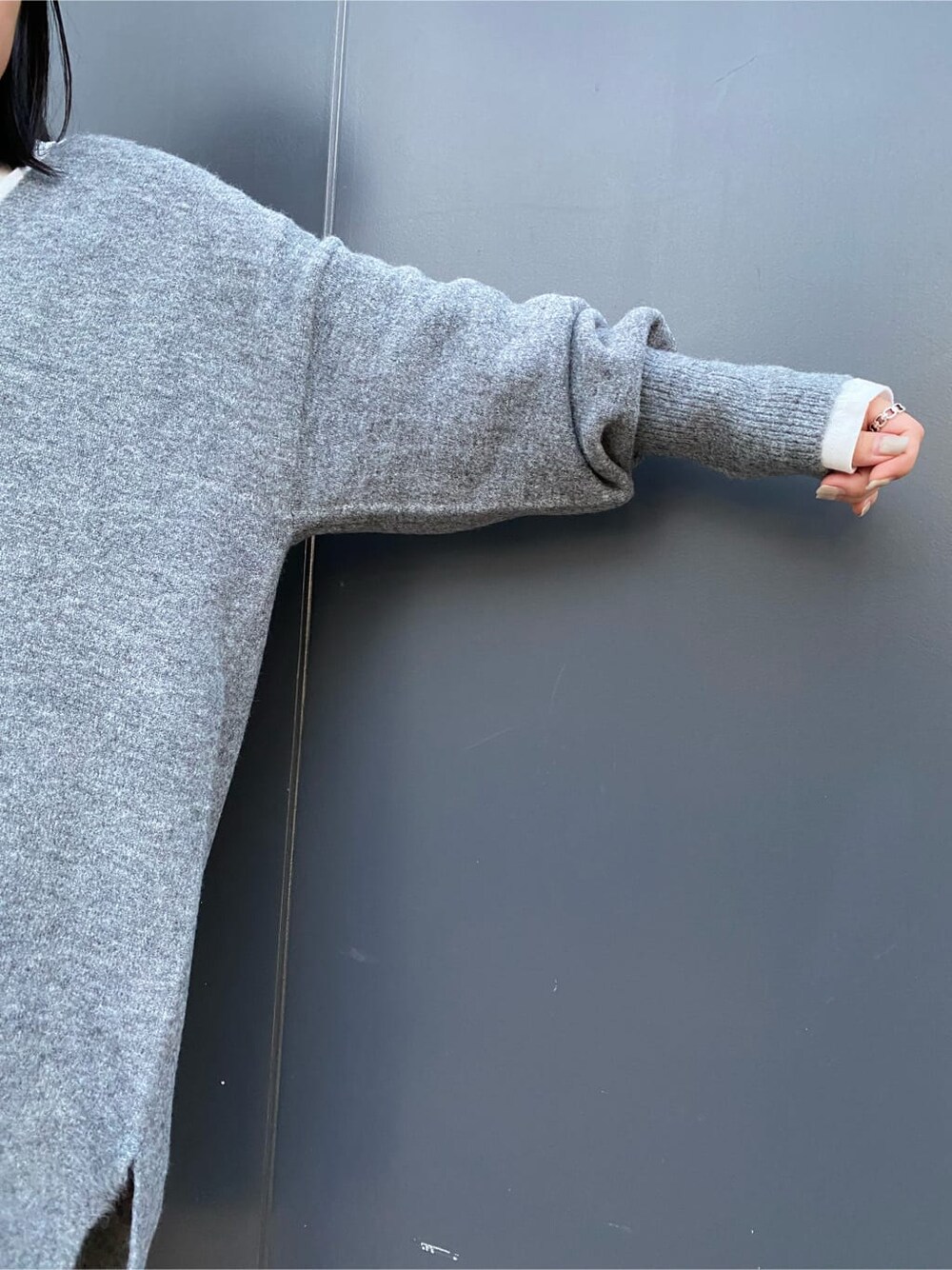 ホワイト系のTシャツ/カットソー、グレー系のニット/セーター、ブラック系のブーツを着用したレディースの秋コーディネートの8枚目の写真