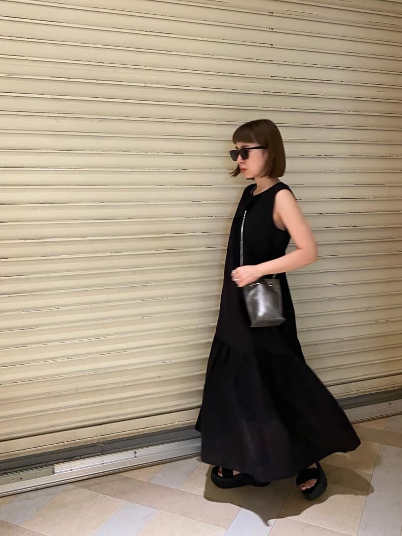 ブラック系のサンダル、ブラック系のショルダーバッグ、ブラウン系のワンピースを着用したレディースの夏コーディネートの2枚目の写真