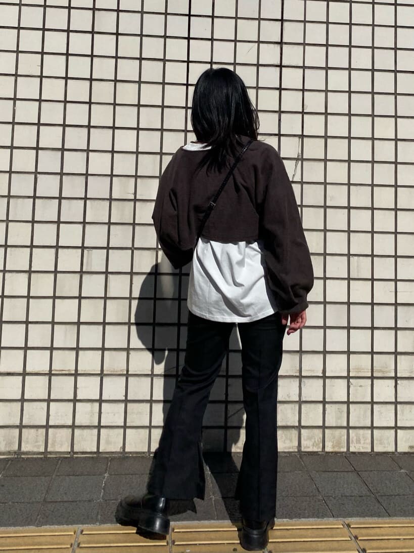 ブラック系のハンドバッグ、ブラック系のスラックス、ブラック系のブーツを着用したレディースの冬コーディネートの3枚目の写真