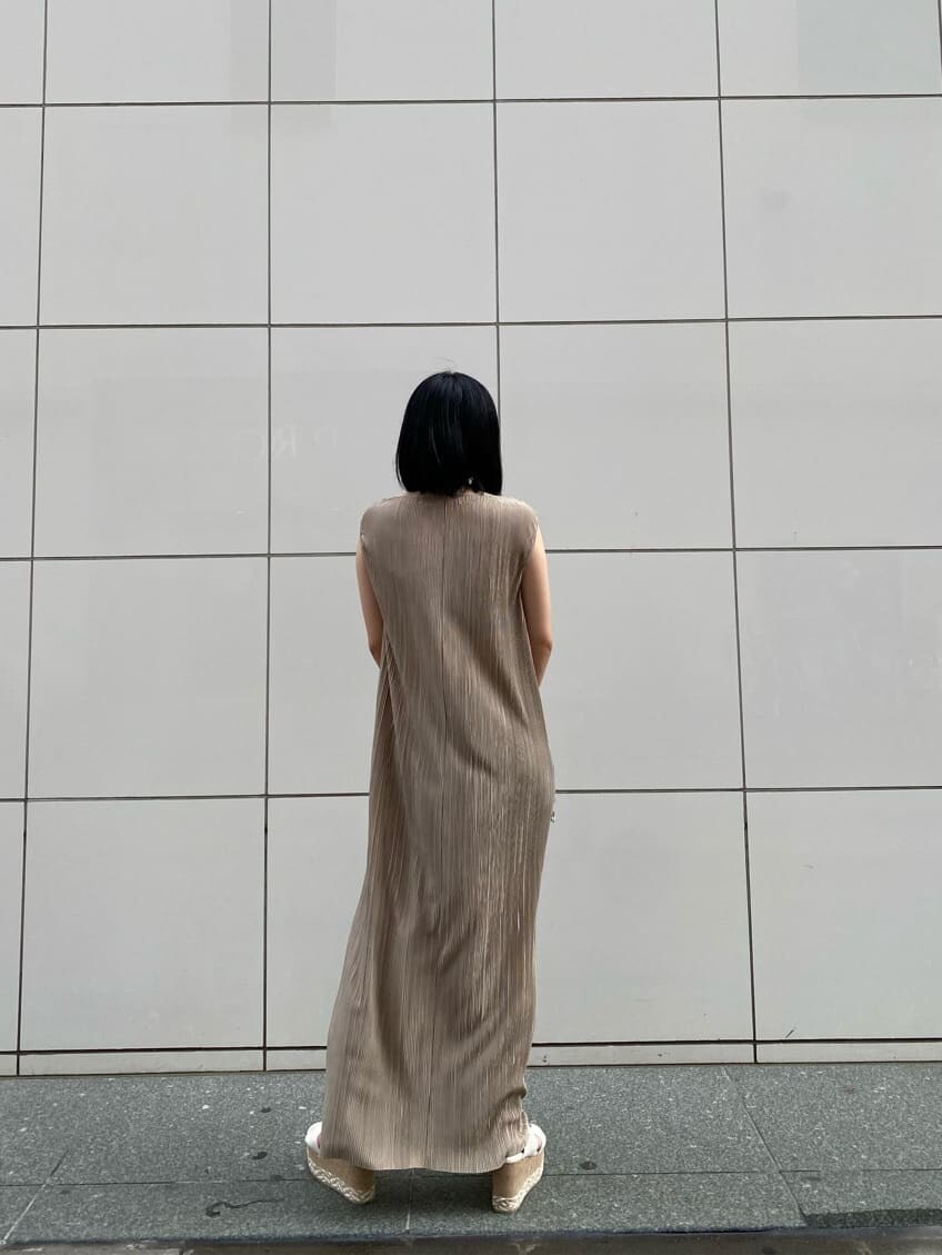 ホワイト系のサンダル、ベージュ系のワンピース、ブラウン系のハンドバッグを着用したレディースの夏コーディネートの2枚目の写真