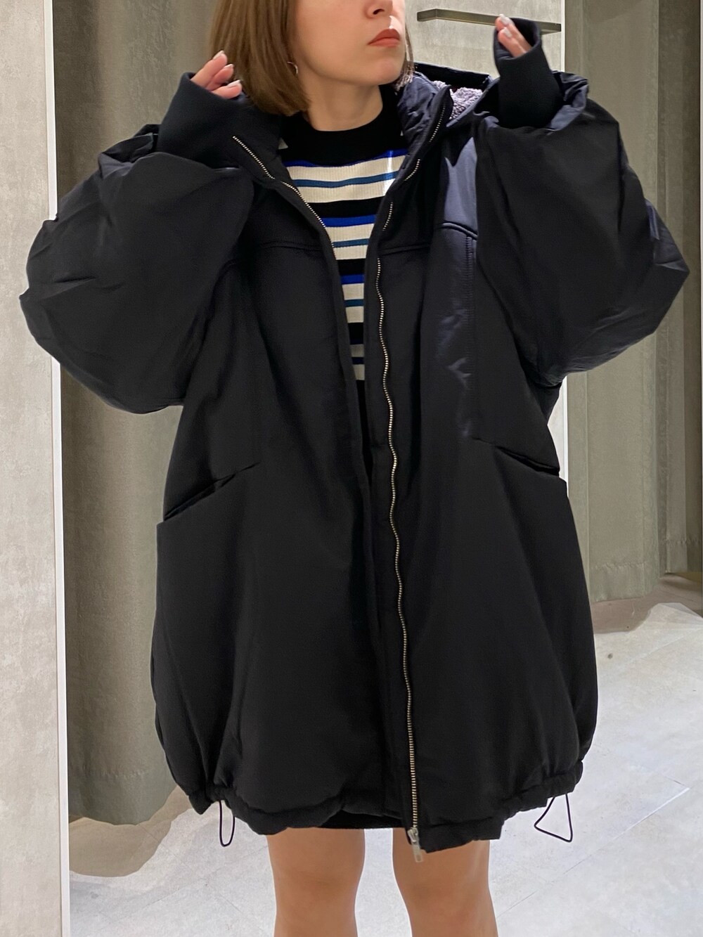 ブラック系のブルゾン、ブルー系のニット/セーター、ブラック系のスカートを着用したレディースの秋コーディネートの7枚目の写真