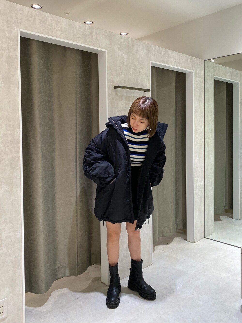 ブラック系のブルゾン、ブルー系のニット/セーター、ブラック系のスカートを着用したレディースの秋コーディネートの2枚目の写真