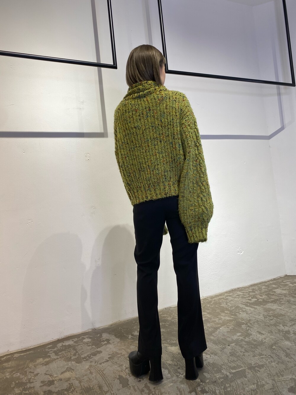 グリーン系のニット/セーター、ブラック系のスウェットパンツ、ブラック系のブーツを着用したレディースの冬コーディネートの5枚目の写真