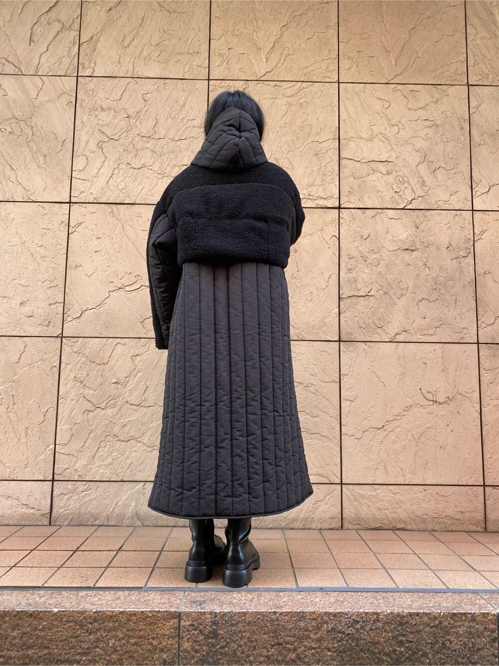 ブラック系のワンピース、ブラック系のダウンジャケット/コート、ブラック系のブーツを着用したレディースの冬コーディネートの4枚目の写真