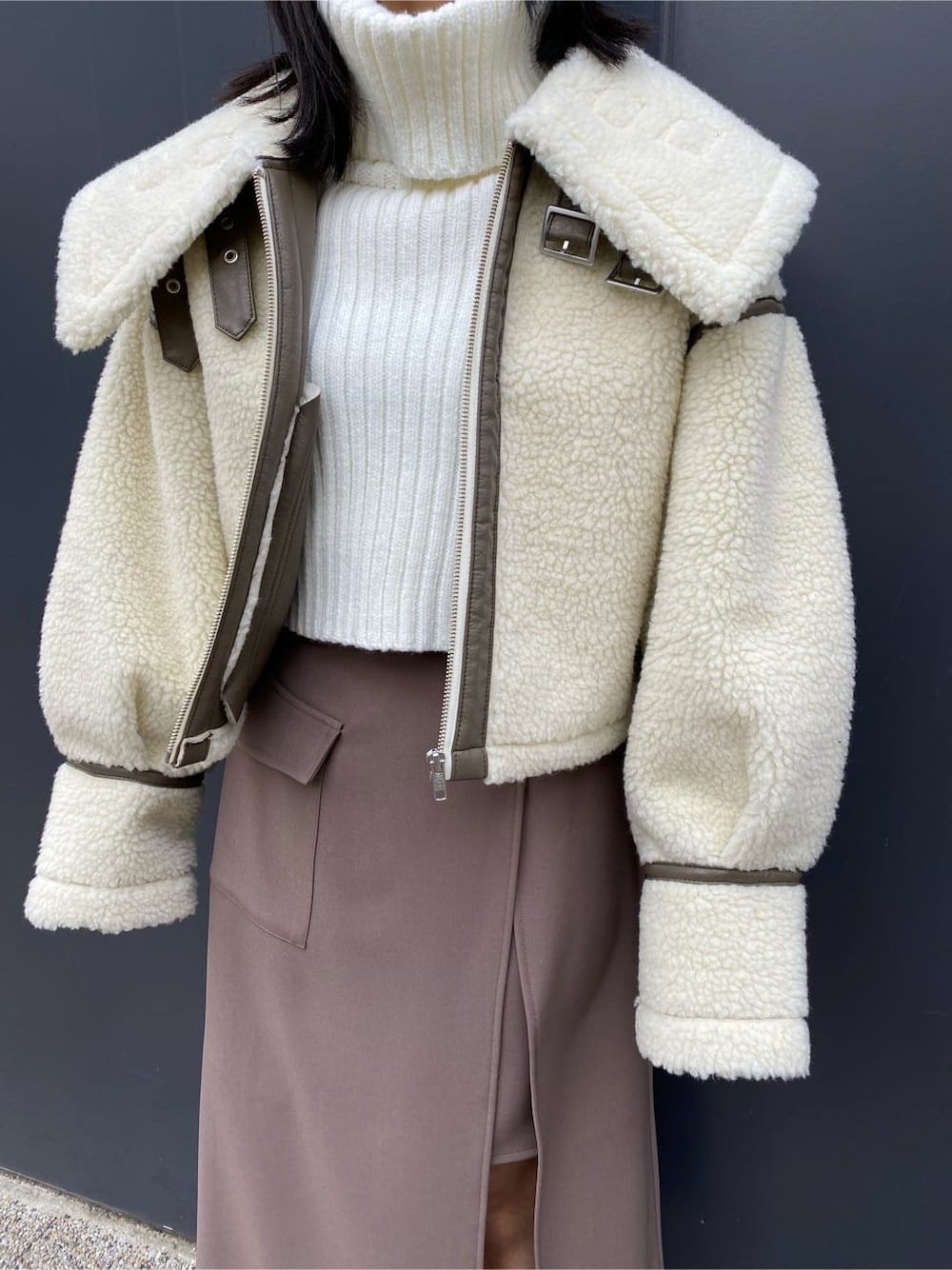 ベージュ系のスカート、ホワイト系のブルゾン、ブラウン系のブーツを着用したレディースの冬コーディネートの3枚目の写真