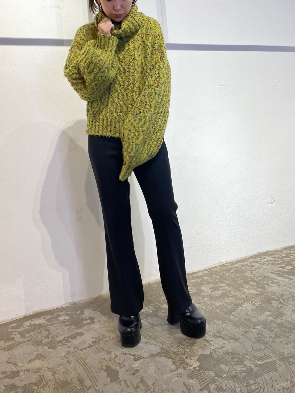 グリーン系のニット/セーター、ブラック系のスウェットパンツ、ブラック系のブーツを着用したレディースの冬コーディネートの4枚目の写真