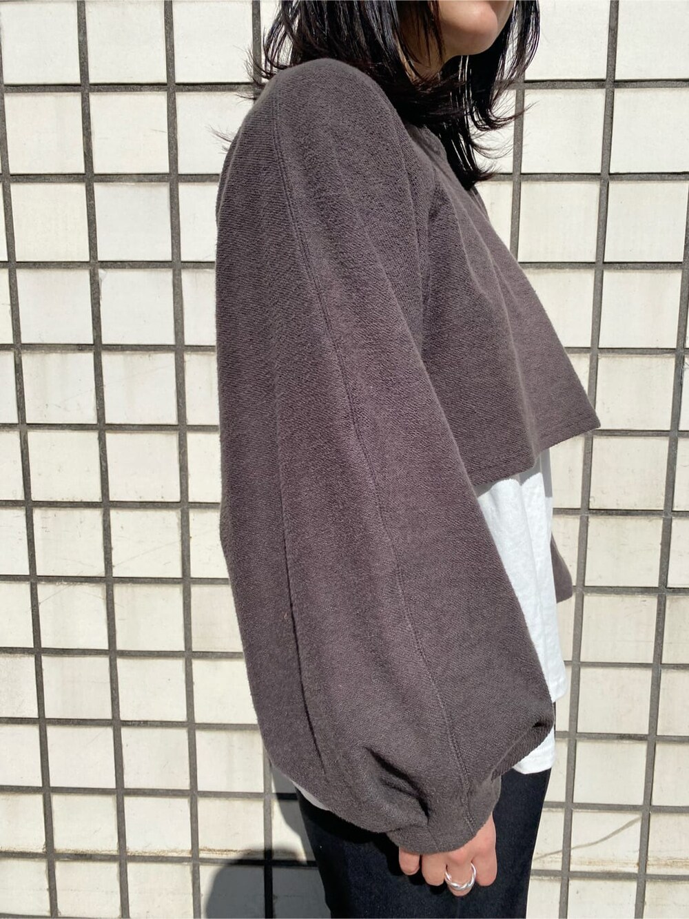 ブラック系のハンドバッグ、ブラック系のスラックス、ブラック系のブーツを着用したレディースの冬コーディネートの5枚目の写真