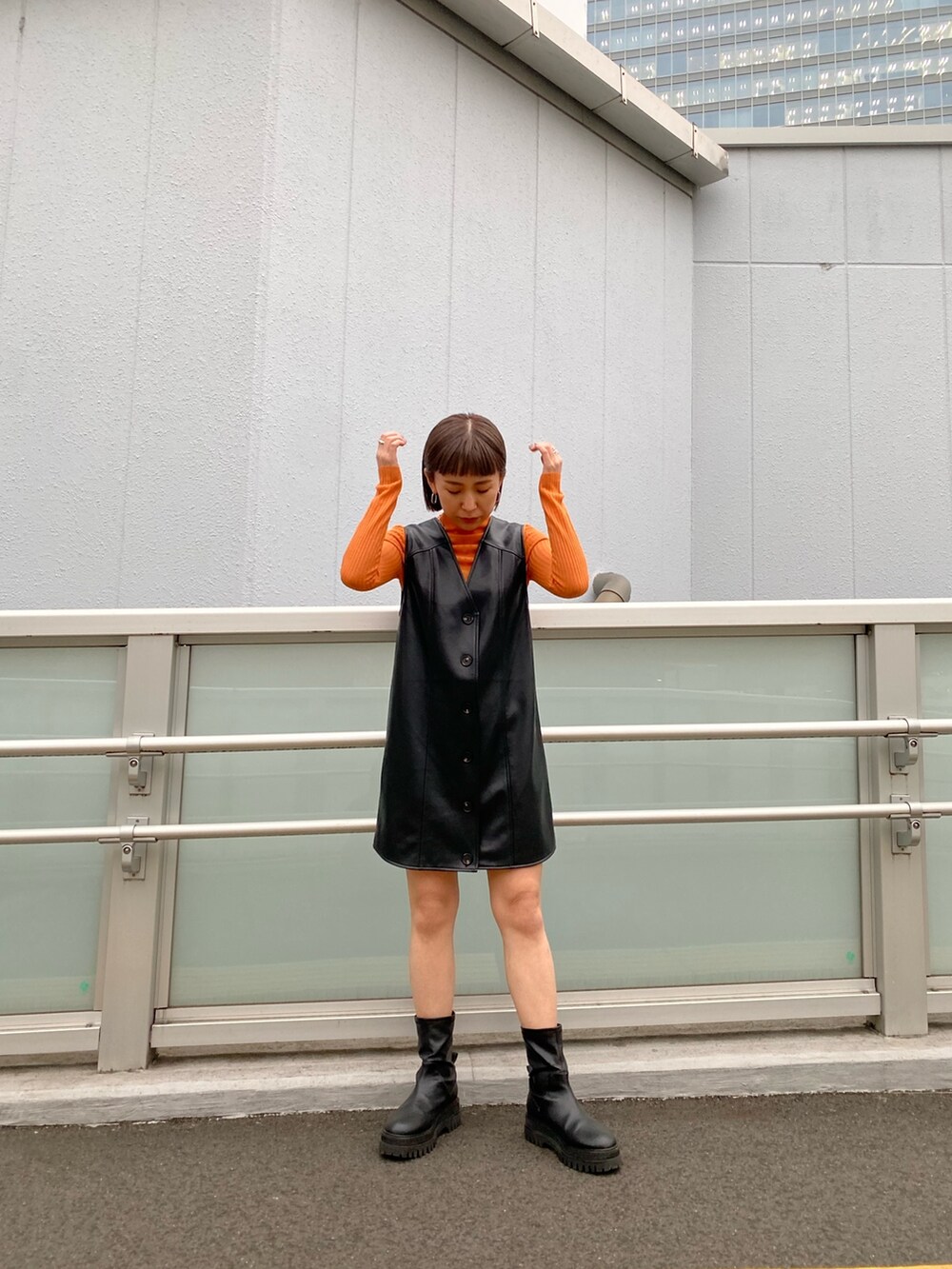 ブラック系のワンピース、ブラック系のMA-1、オレンジ系のニット/セーターを着用したレディースの冬コーディネートの4枚目の写真