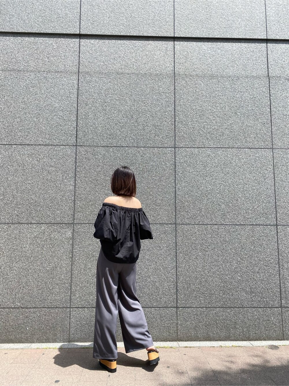 ブラック系のシャツ/ブラウス、ブラック系のサンダル、グレー系のその他パンツを着用したレディースの夏コーディネートの3枚目の写真