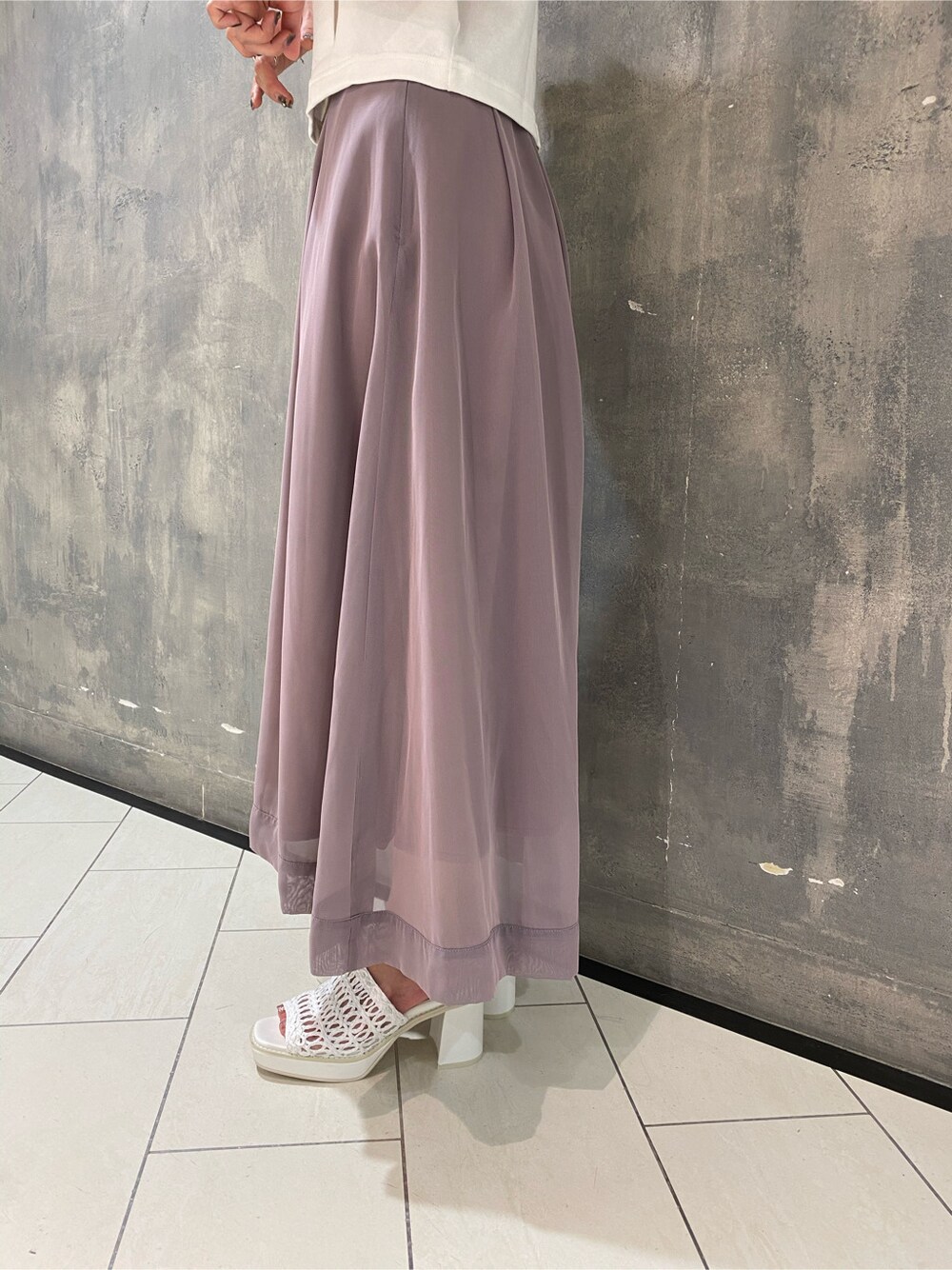 パープル系のスカート、ホワイト系のサンダル、ホワイト系のタンクトップを着用したレディースの夏コーディネートの4枚目の写真