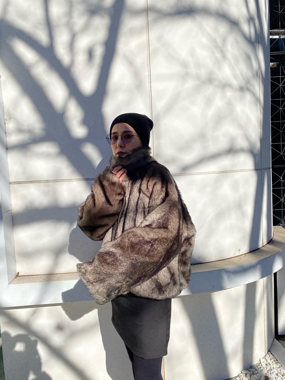 グレー系のブルゾン、ブラック系のニット/セーター、ブラック系のスカートを着用したレディースの冬コーディネートの3枚目の写真