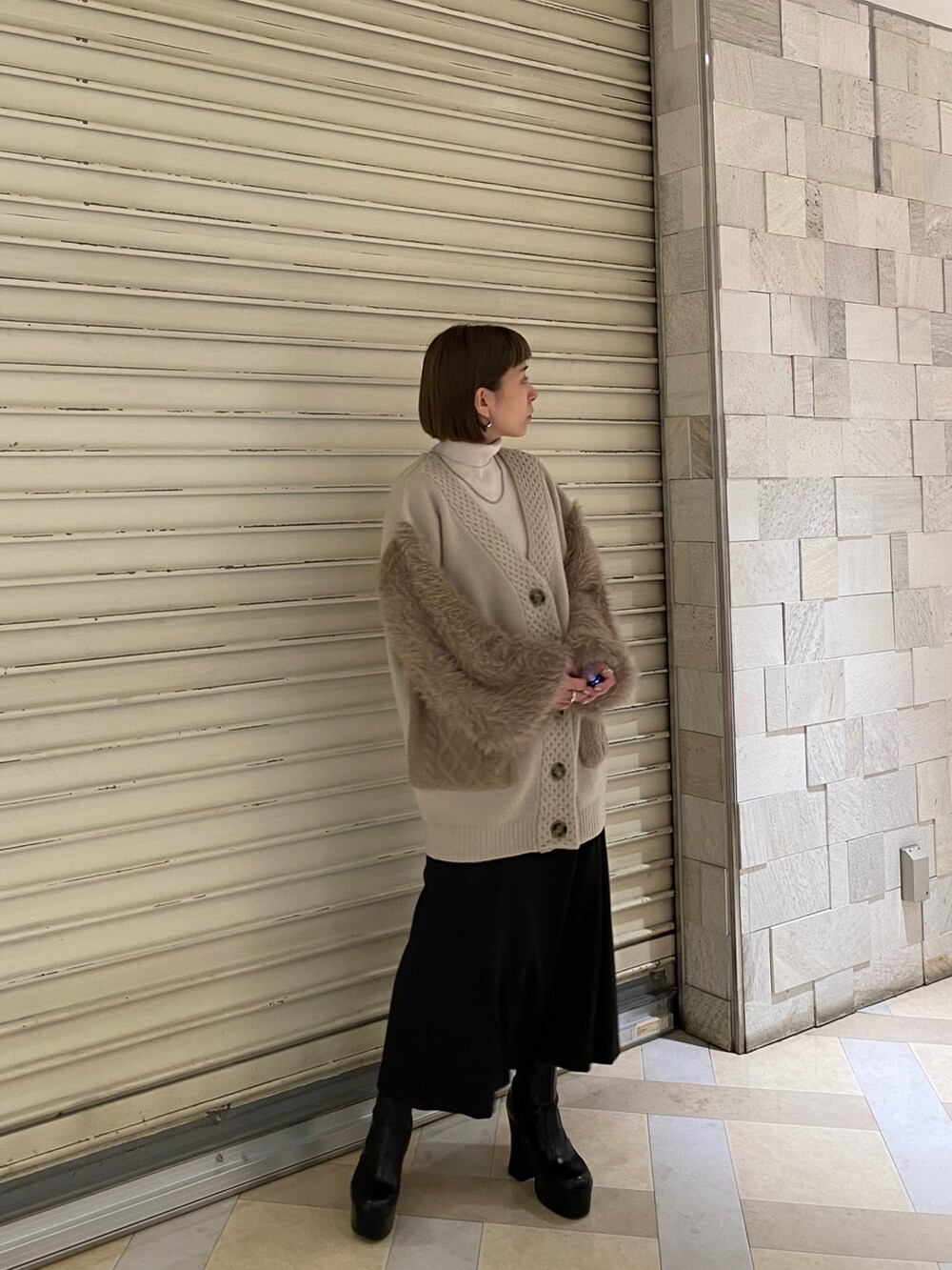 ベージュ系のカーディガン/ボレロ、その他のスカート、ブラック系のブーツを着用したレディースの秋コーディネートの3枚目の写真