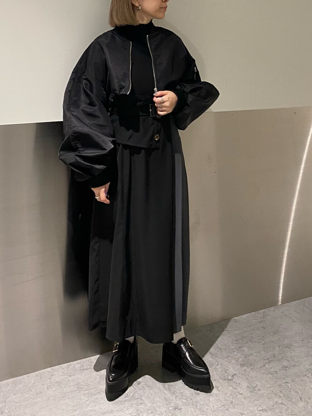 ブラック系のMA-1、ブラック系のワンピース、ブラック系のローファーを着用したレディースの冬コーディネートの2枚目の写真