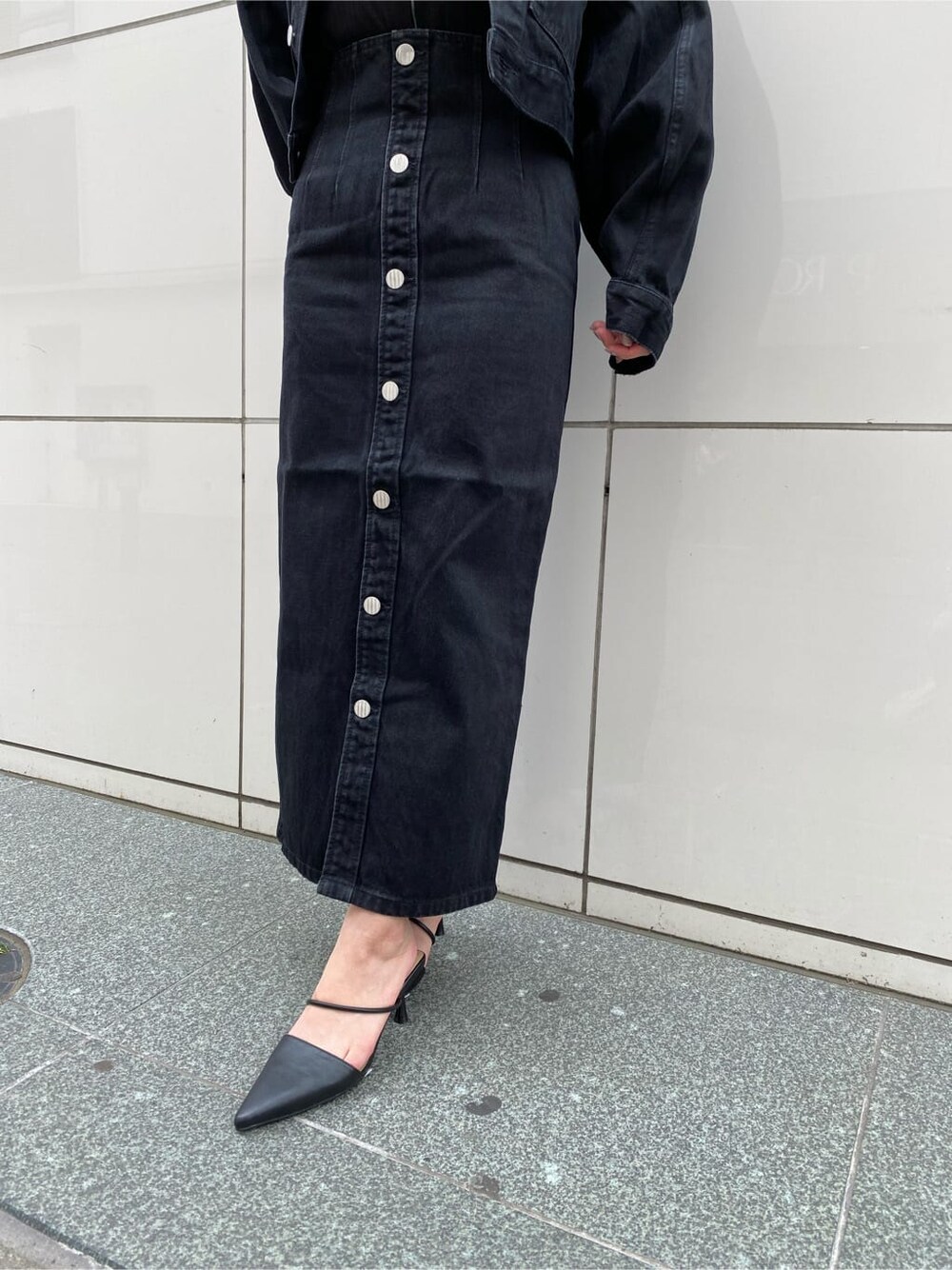 ブラック系のスカート、ブラック系のパンプス、ブラック系のブルゾンを着用したレディースの夏コーディネートの7枚目の写真