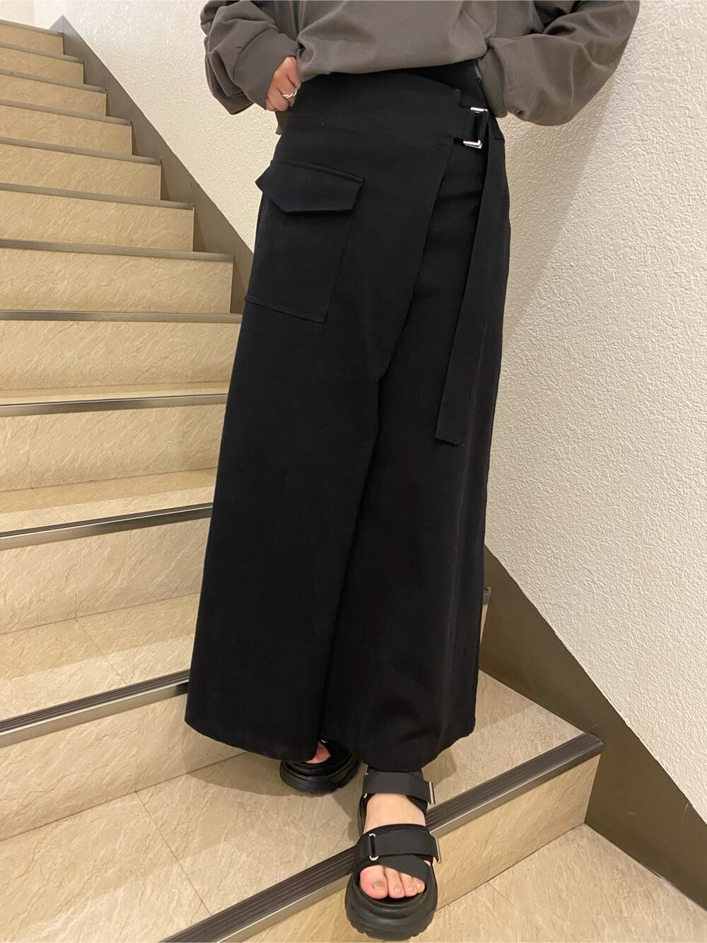 ブラック系のスカート、ブラック系のサンダル、グレー系のTシャツ/カットソーを着用したレディースの春コーディネートの7枚目の写真