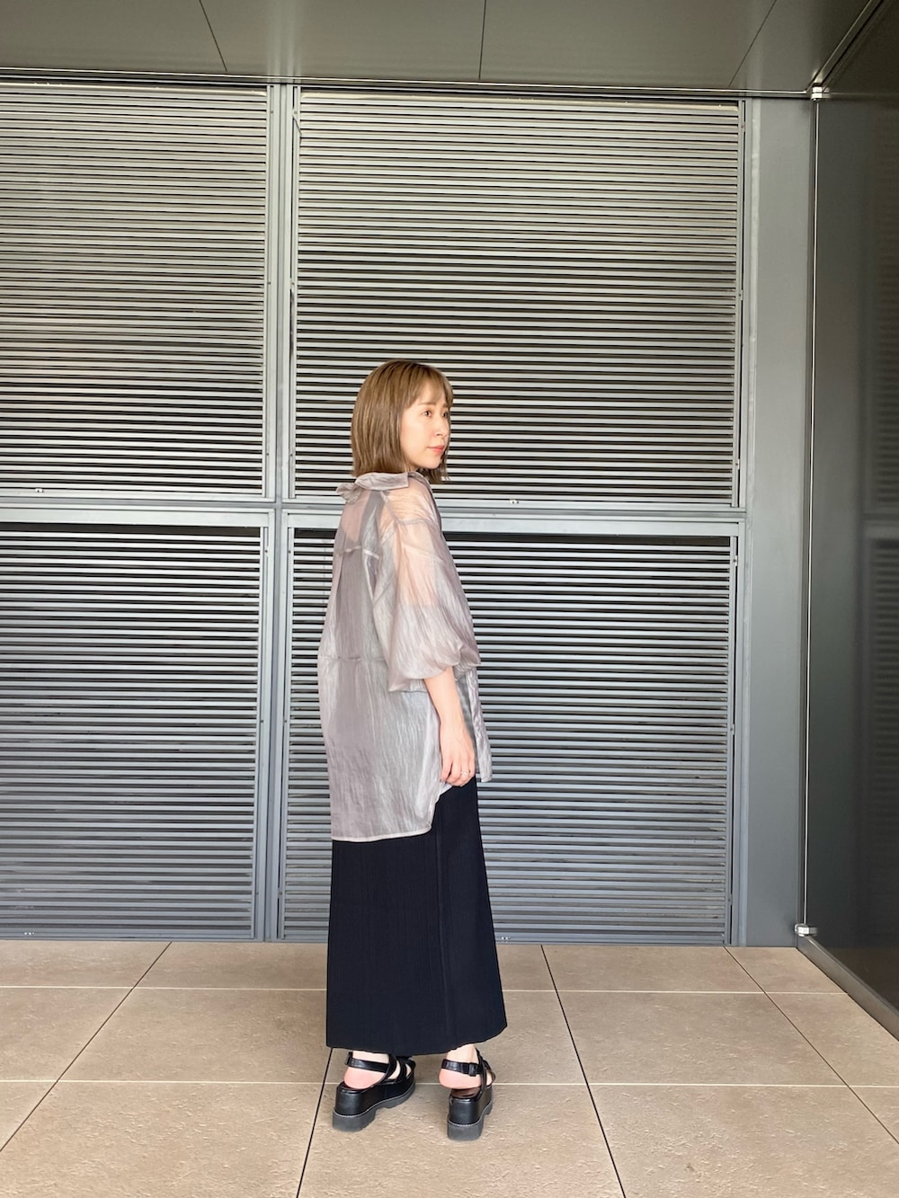 グレー系のシャツ/ブラウス、ブラック系のワンピース、ブラック系のサンダルを着用したレディースの春コーディネートの3枚目の写真