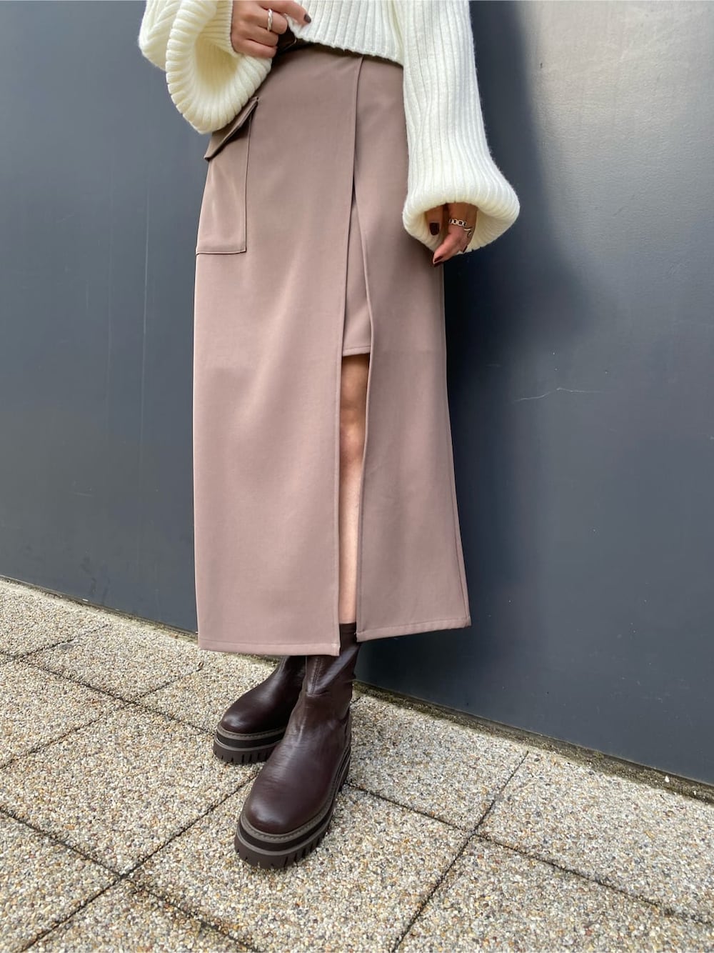 ベージュ系のスカート、ホワイト系のブルゾン、ブラウン系のブーツを着用したレディースの冬コーディネートの9枚目の写真