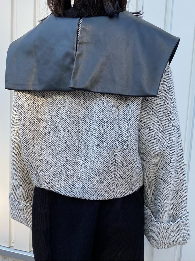 ブラック系のワンピース、ホワイト系のブルゾン、ブラック系のブーツを着用したレディースの秋コーディネートの7枚目の写真