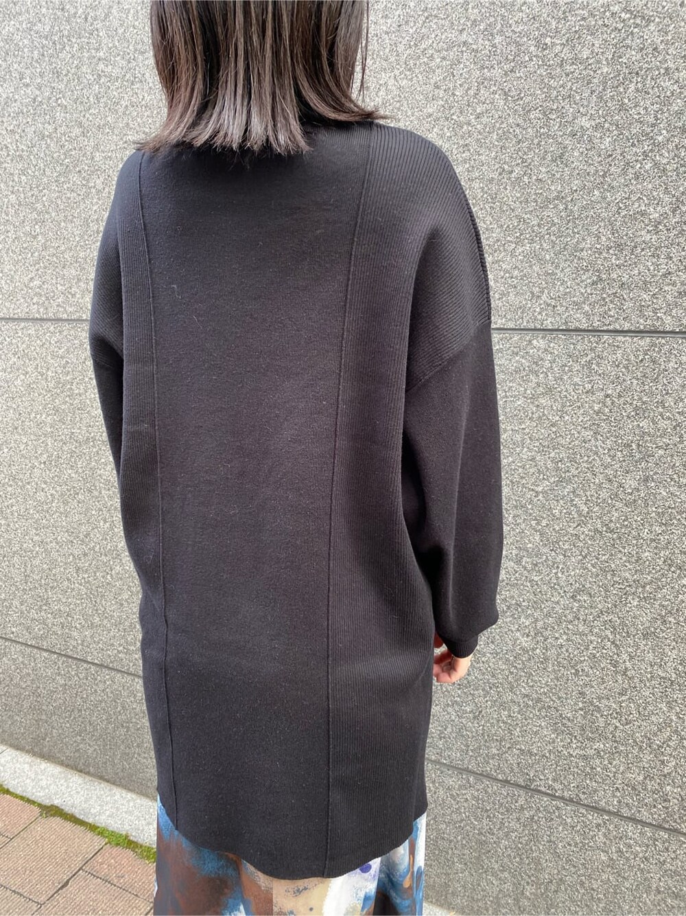 ブラック系のワンピース、ブルー系のスカート、ブラック系のブーツを着用したレディースの秋コーディネートの6枚目の写真