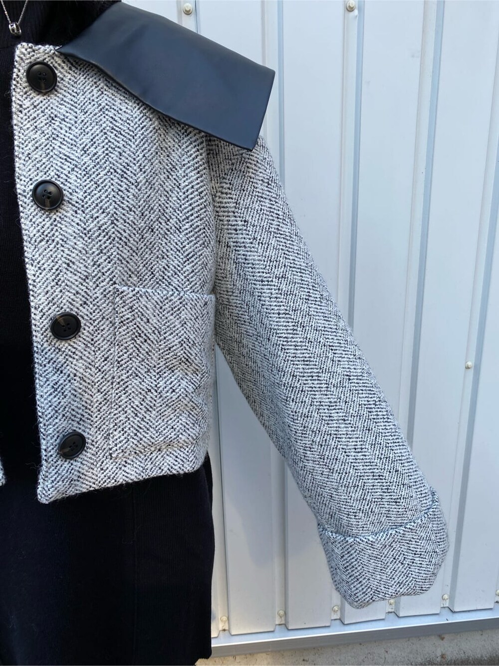 ブラック系のワンピース、ホワイト系のブルゾン、ブラック系のブーツを着用したレディースの秋コーディネートの6枚目の写真