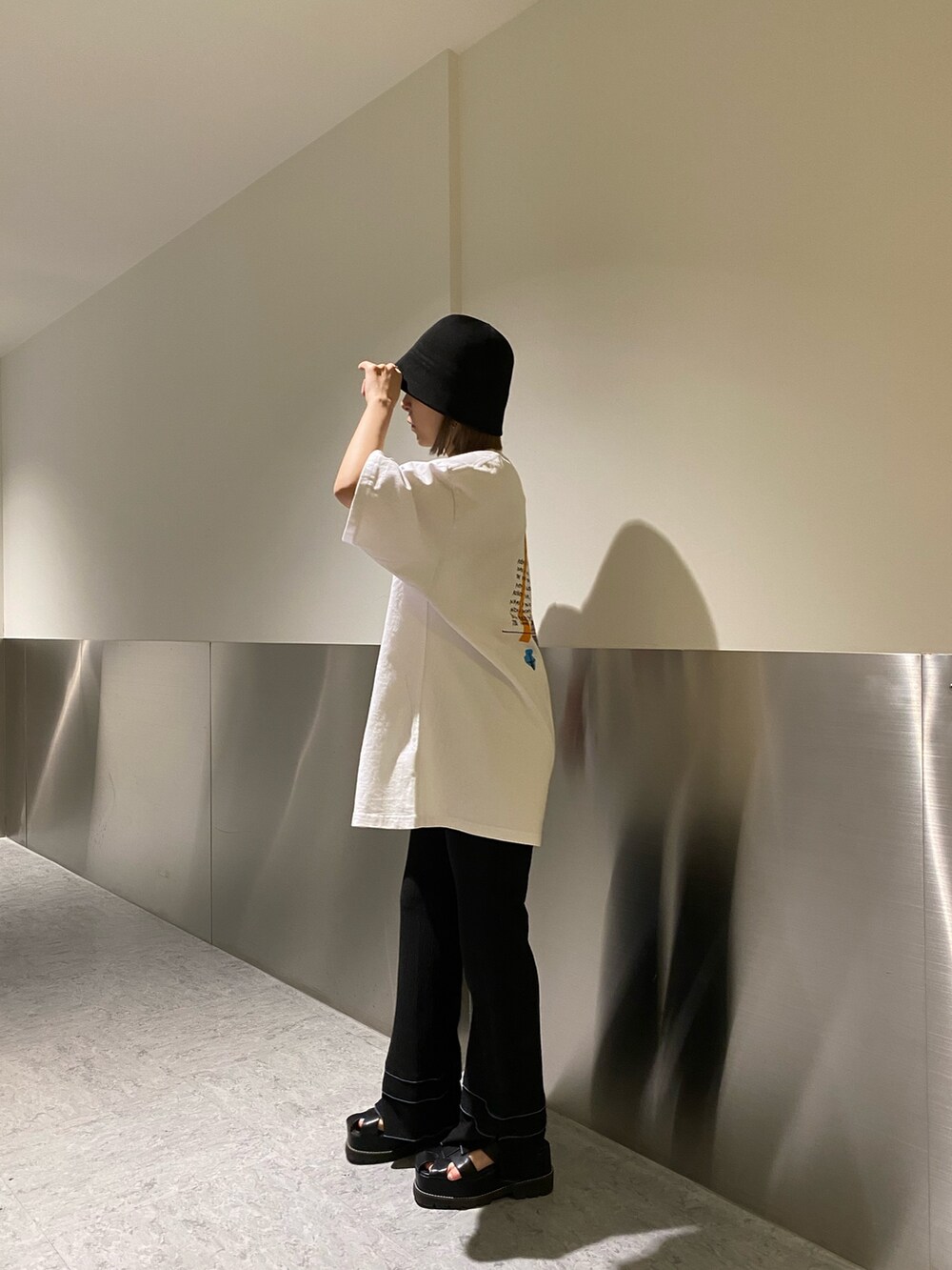 ホワイト系のTシャツ/カットソー、ブラック系のその他パンツ、ブラック系のサンダルを着用したレディースの春コーディネートの4枚目の写真