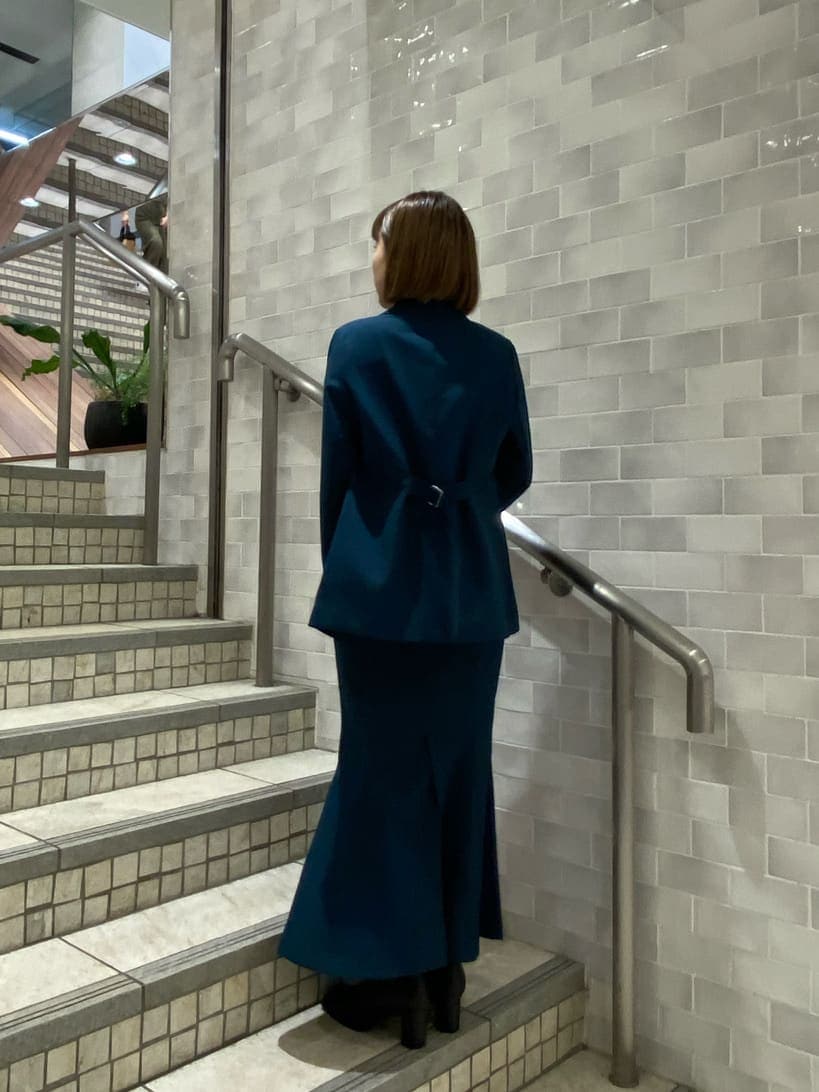 ブラック系のタンクトップ、グリーン系のテーラードジャケット、グリーン系のスカートを着用したレディースの夏コーディネートの3枚目の写真