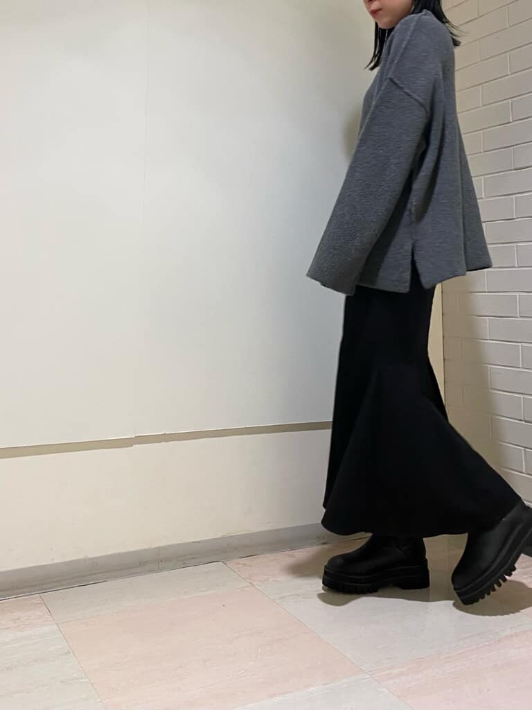 ブラック系のブーツ、グレー系のニット/セーター、ブラック系のスカートを着用したレディースの冬コーディネートの5枚目の写真