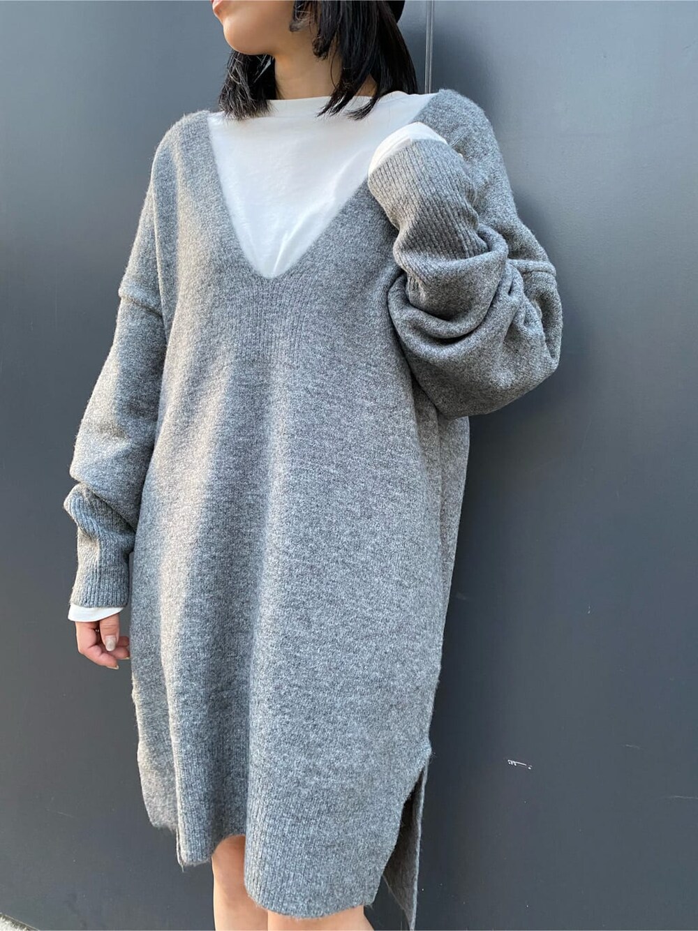 ホワイト系のTシャツ/カットソー、グレー系のニット/セーター、ブラック系のブーツを着用したレディースの秋コーディネートの5枚目の写真