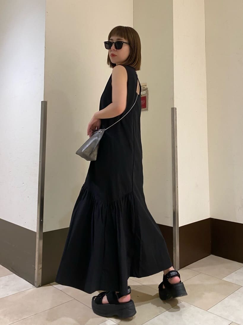 ホワイト系のサンダル、ブラック系のショルダーバッグ、ブラック系のワンピースを着用したレディースの夏コーディネートの5枚目の写真