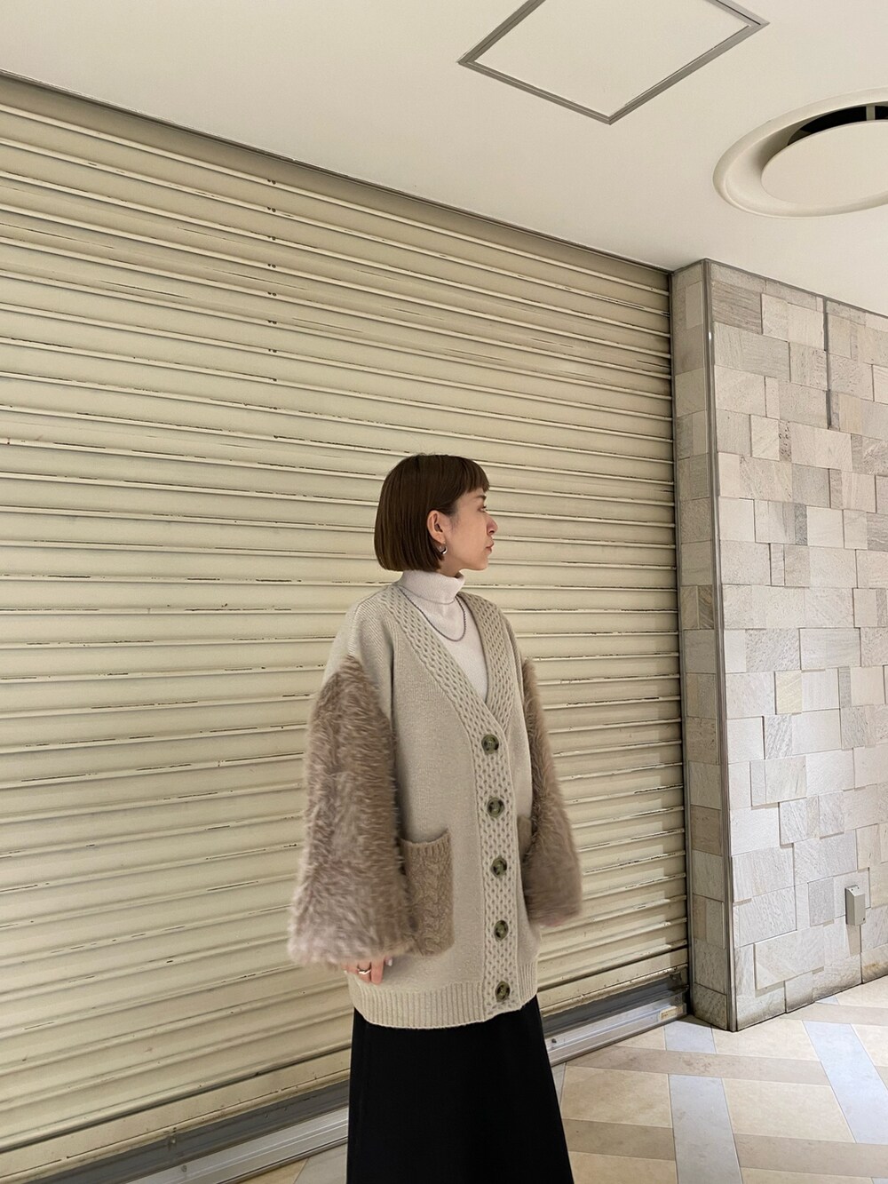 ベージュ系のカーディガン/ボレロ、その他のスカート、ブラック系のブーツを着用したレディースの秋コーディネートの6枚目の写真