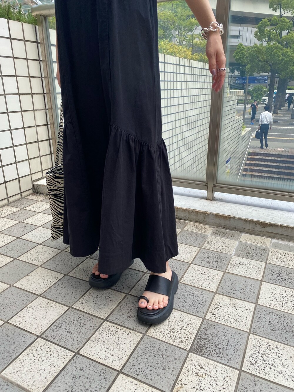 ブラック系のワンピース、その他のトートバッグ、ブラック系のサンダルを着用したレディースの夏コーディネートの6枚目の写真