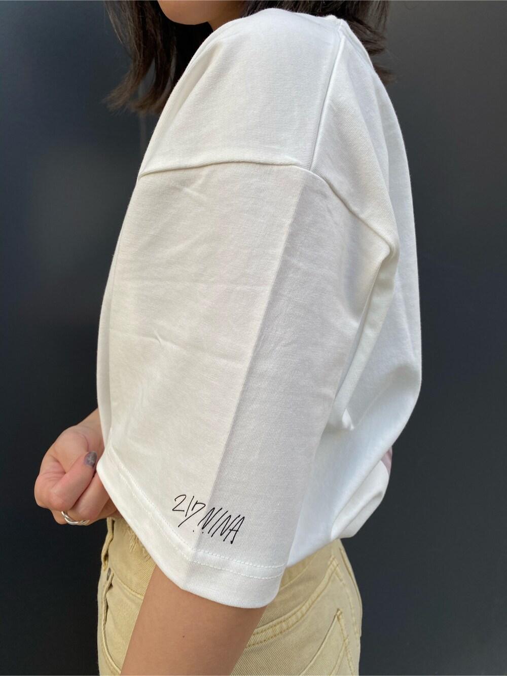 ベージュ系のかごバッグ、イエロー系のその他パンツ、ホワイト系のTシャツ/カットソーを着用したレディースの春コーディネートの2枚目の写真