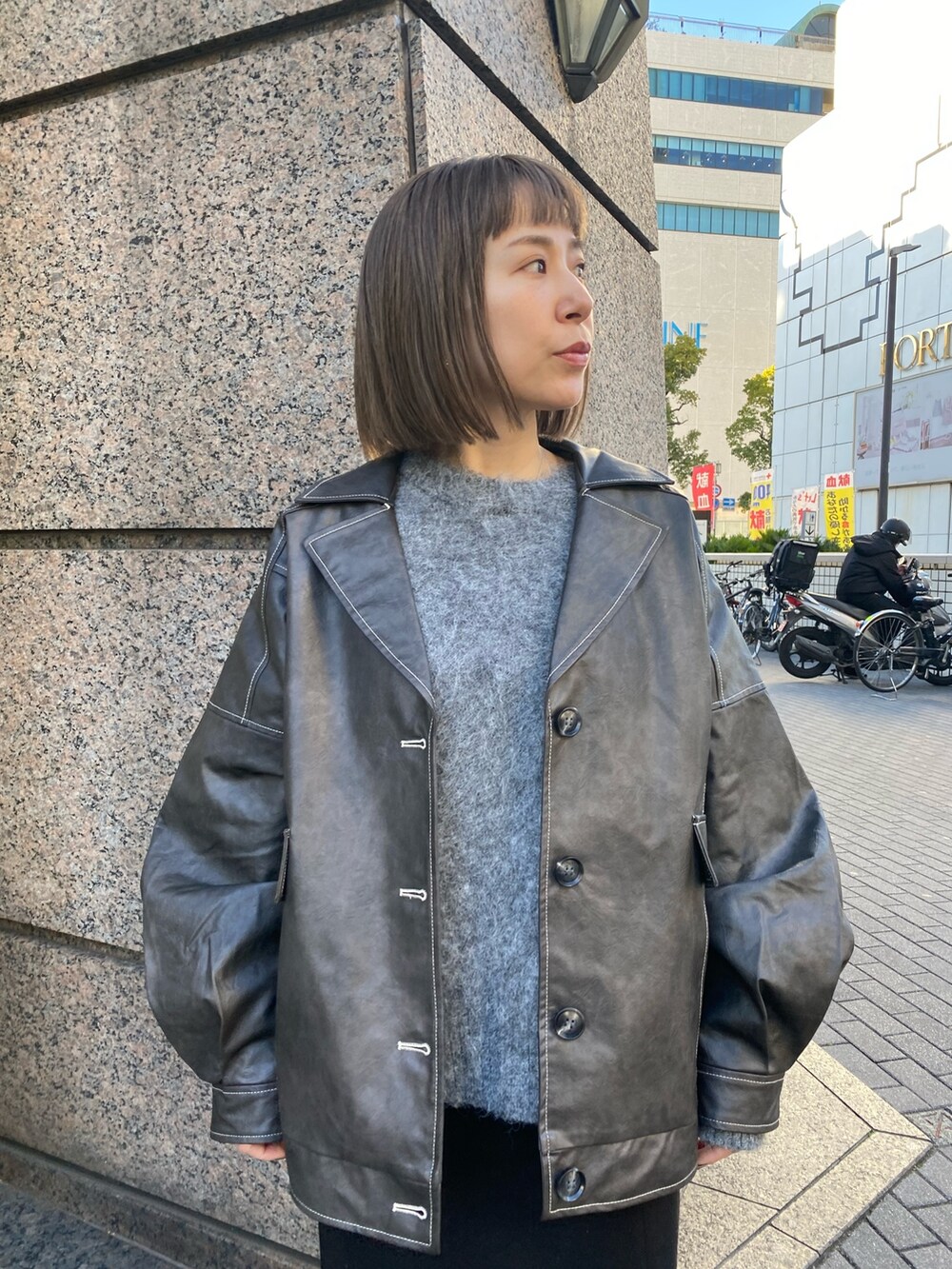 グレー系のブルゾン、グレー系のニット/セーター、ブラック系のスカートを着用したレディースの冬コーディネートの4枚目の写真