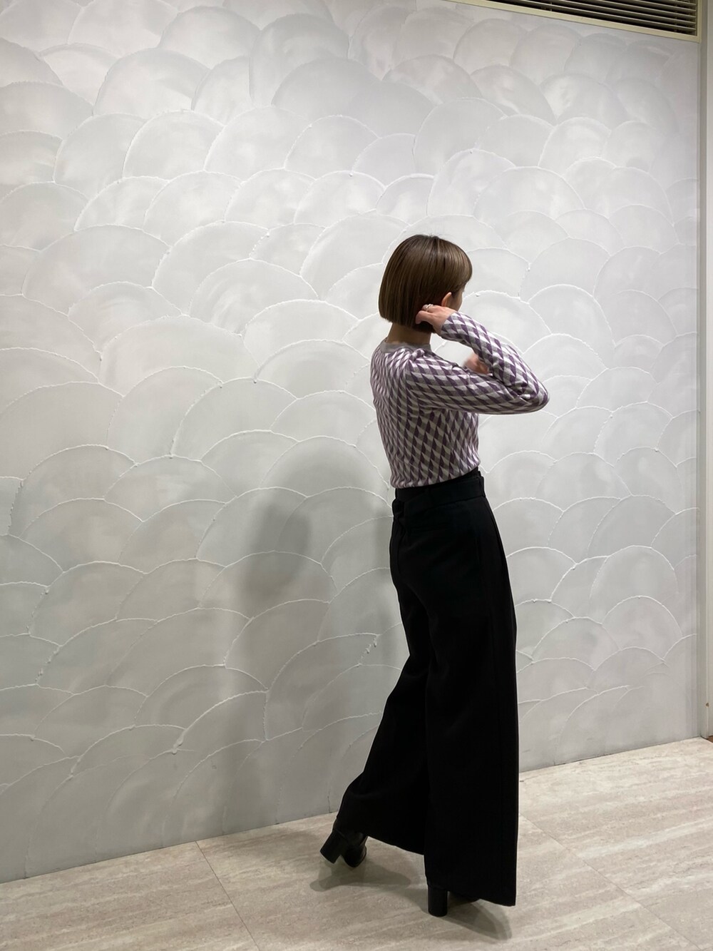 ブラック系のニット/セーター、ブラック系のスラックス、ブラック系のブーツを着用したレディースの冬コーディネートの4枚目の写真