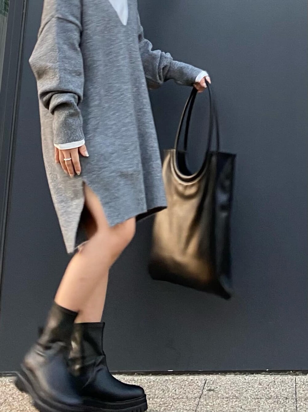 ホワイト系のTシャツ/カットソー、グレー系のニット/セーター、ブラック系のブーツを着用したレディースの秋コーディネートの3枚目の写真