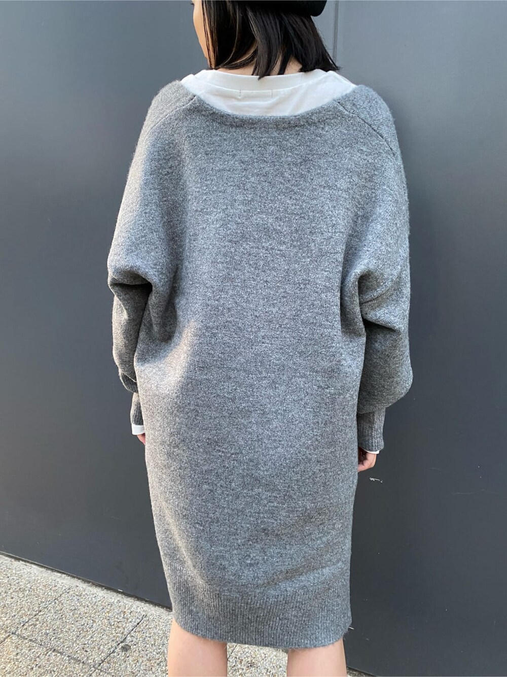 ホワイト系のTシャツ/カットソー、グレー系のニット/セーター、ブラック系のブーツを着用したレディースの秋コーディネートの7枚目の写真