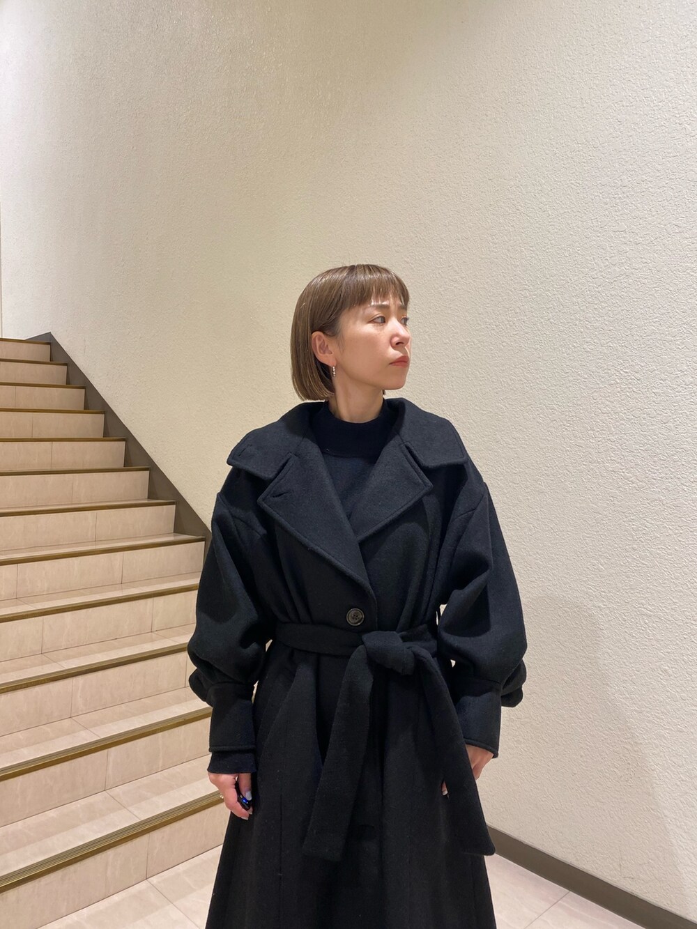 ブラック系のダウンジャケット/コート、パープル系のニット/セーター、グレー系のスラックスを着用したレディースの秋コーディネートの7枚目の写真