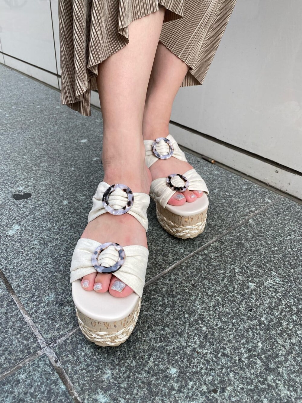 ホワイト系のサンダル、ベージュ系のワンピース、ブラウン系のハンドバッグを着用したレディースの夏コーディネートの6枚目の写真