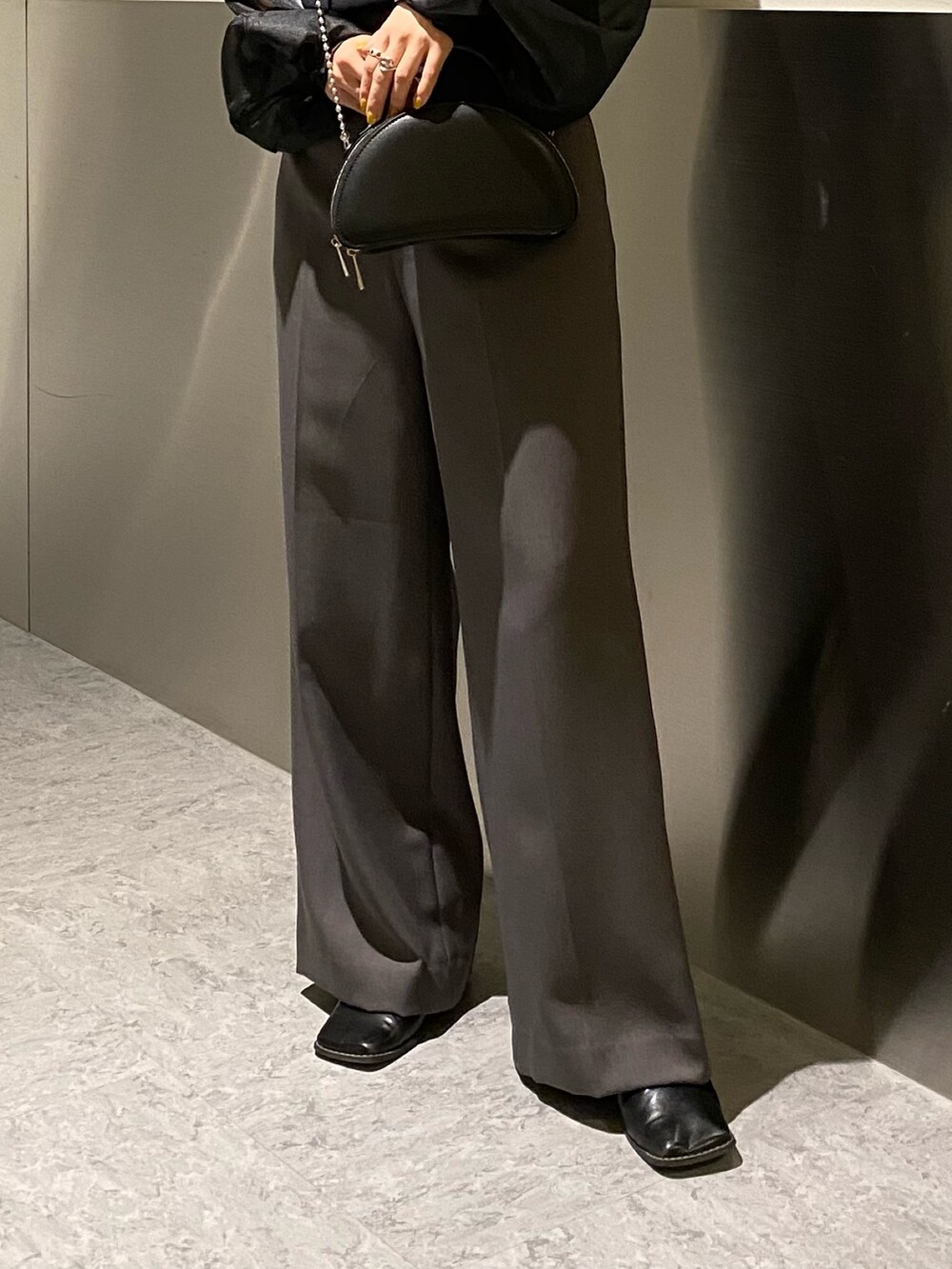 ブラック系のニット/セーター、グレー系のスラックスを着用したレディースの冬コーディネートの7枚目の写真