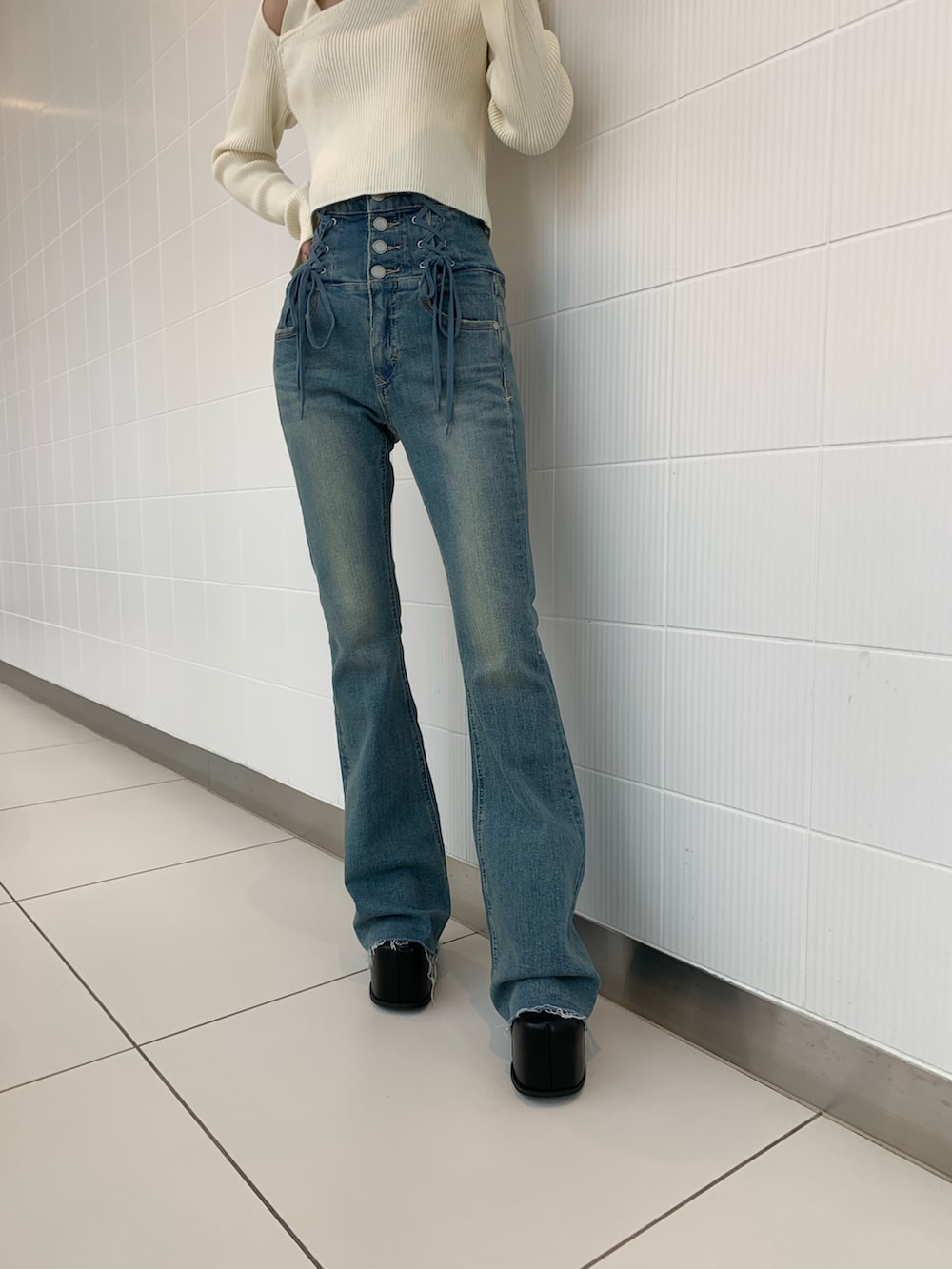 ブラック系のショルダーバッグ、ホワイト系のニット/セーター、ブラック系のブーツを着用したレディースの冬コーディネートの7枚目の写真