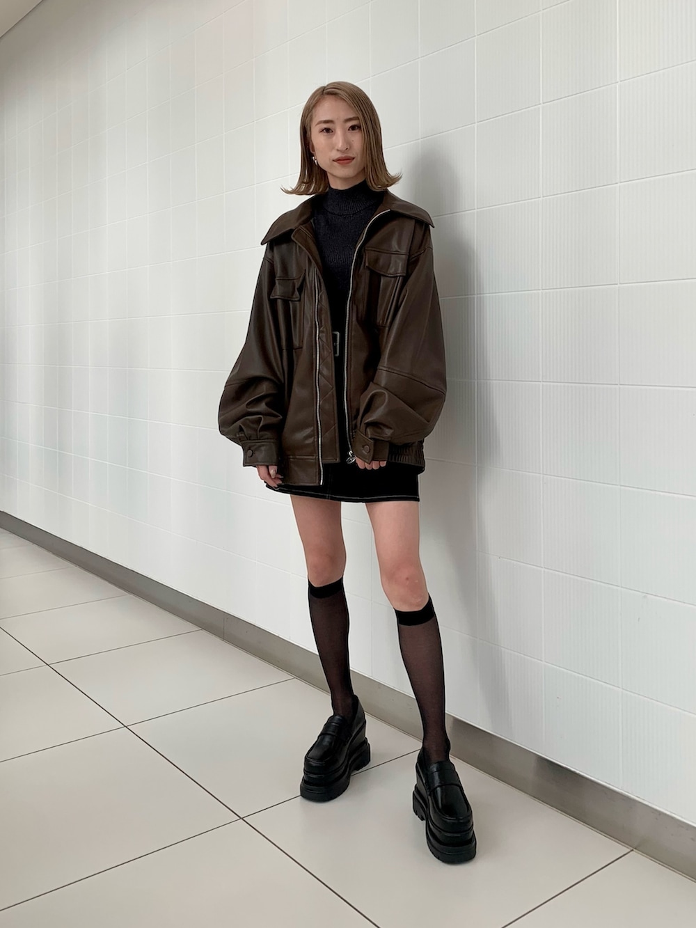 ブラウン系のブルゾン、その他のニット/セーター、ブラック系のスカートを着用したレディースの冬コーディネートの2枚目の写真