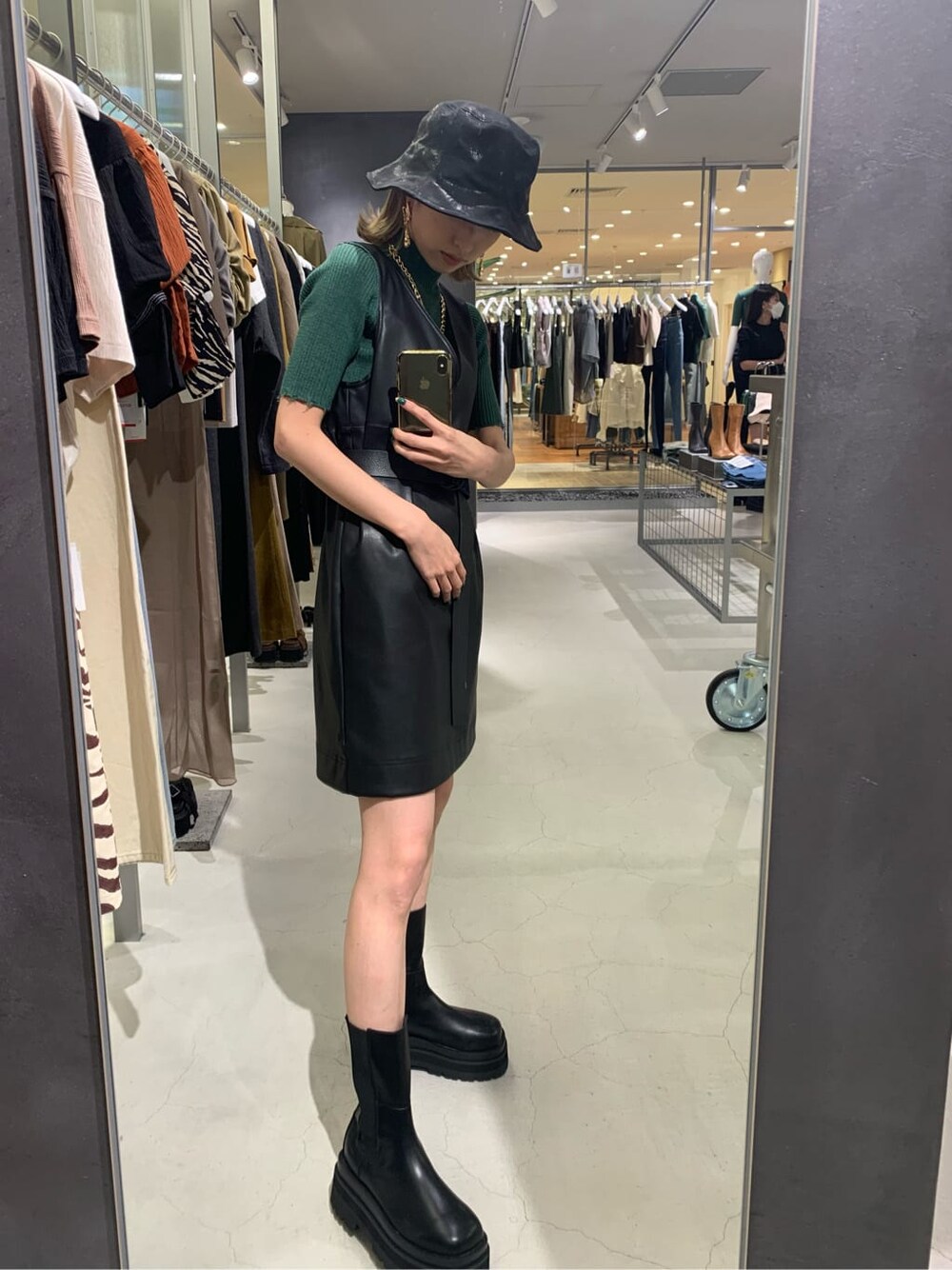 ブラック系のワンピース、グリーン系のニット/セーター、ブラック系のハットを着用したレディースの夏コーディネートの2枚目の写真