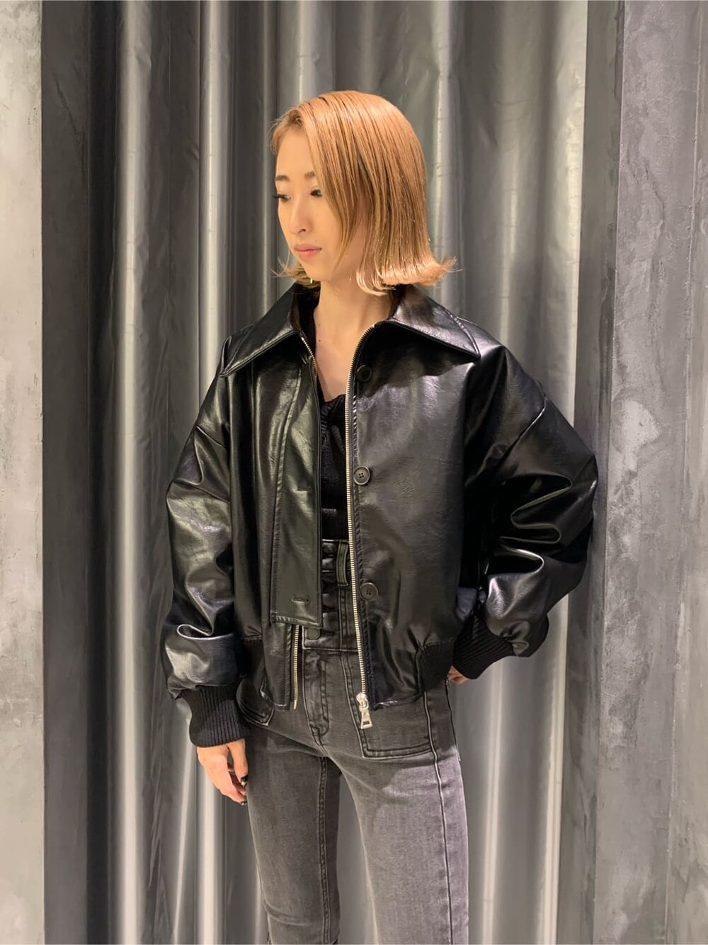 ブラック系のブーツ、グレー系のデニムパンツ、ブラック系のブルゾンを着用したレディースの秋コーディネートの4枚目の写真