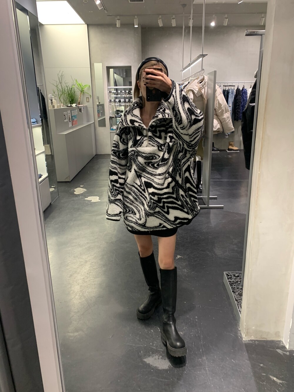 ブラック系のTシャツ/カットソー、ブラック系のブーツ、ブラック系のスカートを着用したレディースの秋コーディネートの3枚目の写真