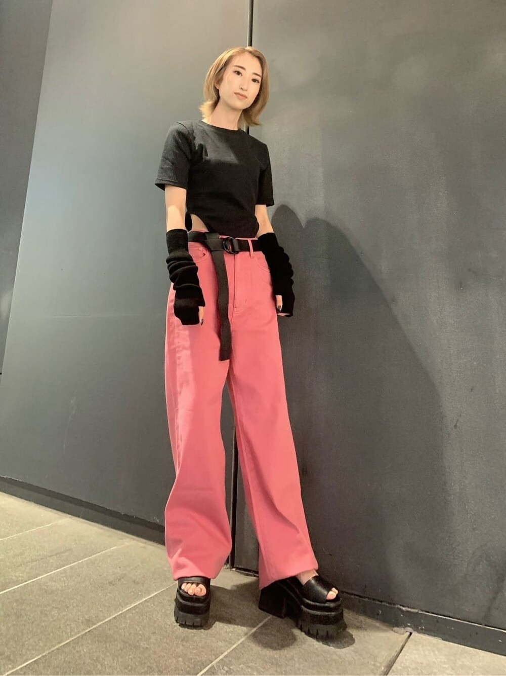 ピンク系のデニムパンツ、ブラック系のサンダル、ブラック系のTシャツ/カットソーを着用したレディースの夏コーディネートの2枚目の写真