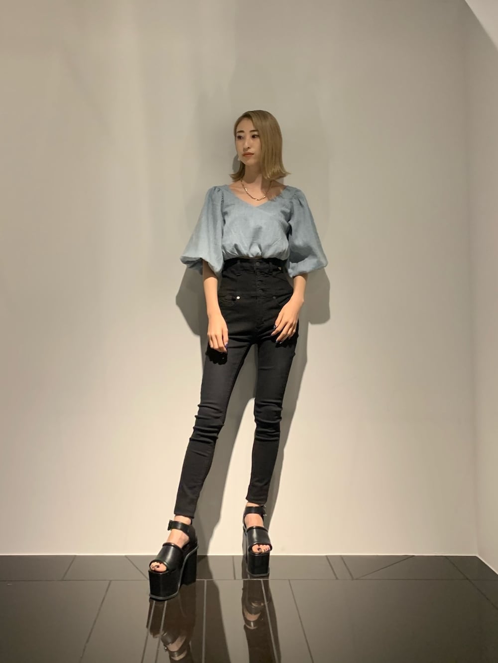 ブルー系のTシャツ/カットソー、ブラック系のデニムパンツ、ブラック系のサンダルを着用したレディースの夏コーディネートの2枚目の写真
