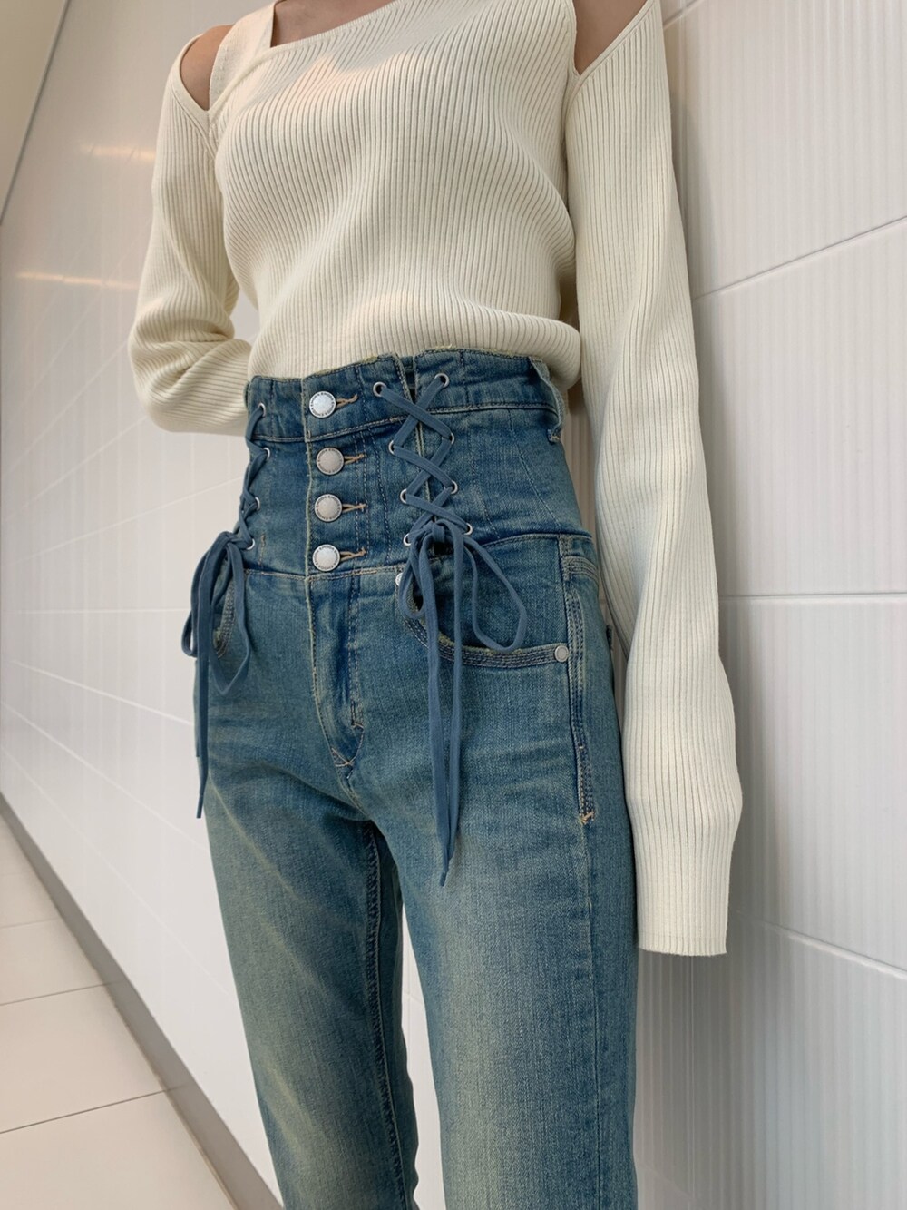 ブラック系のショルダーバッグ、ホワイト系のニット/セーター、ブラック系のブーツを着用したレディースの冬コーディネートの8枚目の写真