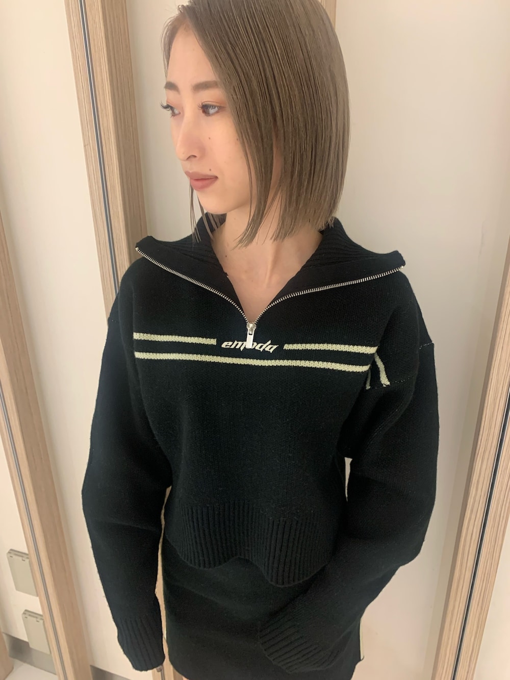 ブラック系のニット/セーター、ブラック系のスカート、ブラック系のブーツを着用したレディースの秋コーディネートの3枚目の写真