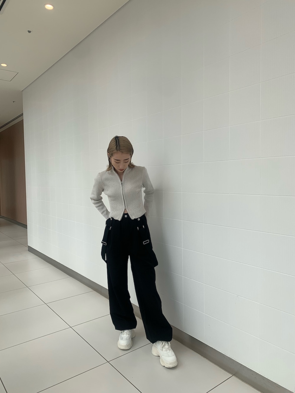 ブラック系のその他パンツ、ホワイト系のニット/セーター、ホワイト系のスニーカーを着用したレディースの冬コーディネートの2枚目の写真