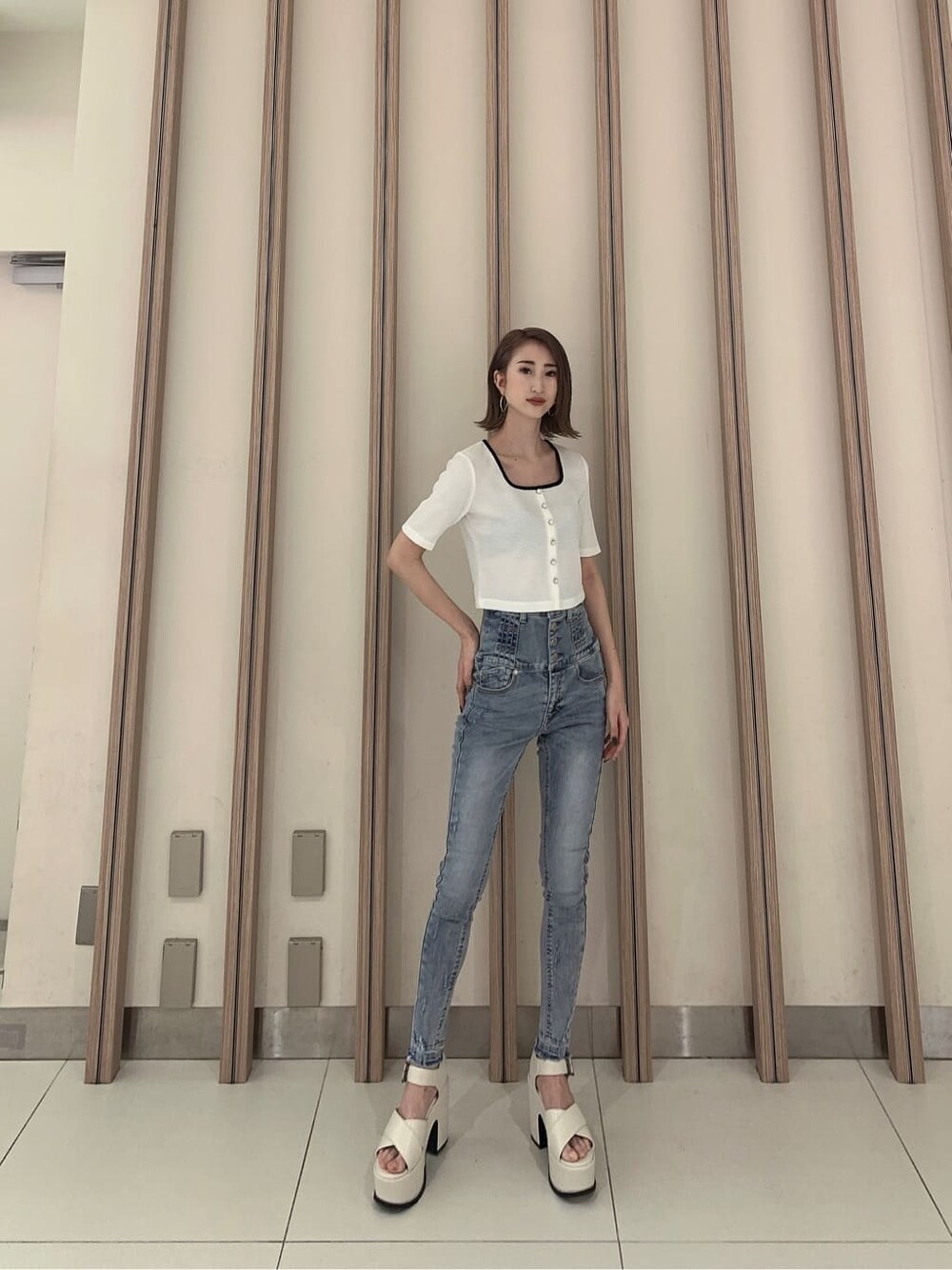 ホワイト系のサンダル、ブルー系のデニムパンツ、ホワイト系のTシャツ/カットソーを着用したレディースの春コーディネートの2枚目の写真